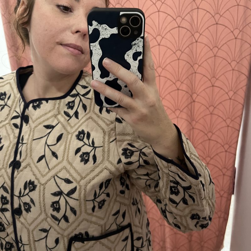 CHAQUETA BORDADA EN BEIGE CON DETALLES AZUL MARINO.